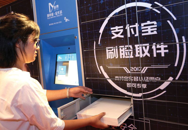 A Shanghai resident tests out a courier service pick-up locker with the latest facial recognition technology developed by Alibaba&#x27;s Ant Financial in September 2017