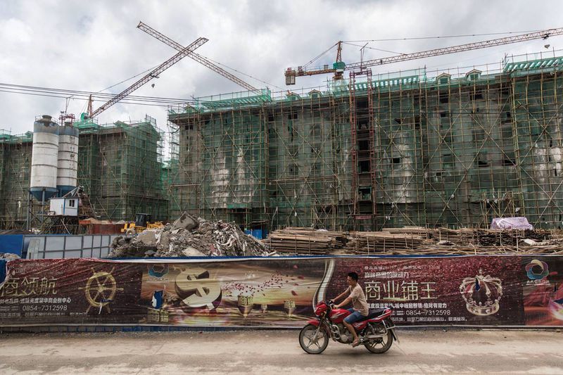 A resident motors past the site of a shopping mall, 2 kilometers from downtown Kedu